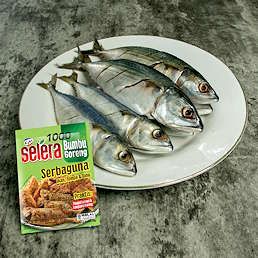Piring berisi ikan segar dan kemasan Selera Bumbu Goreng Serbaguna dari Kobe