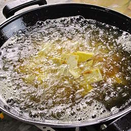 Tahu berbumbu Kobe Selera digoreng dalam minyak panas di wajan