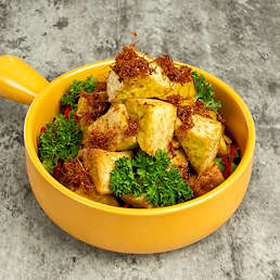 Tahu goreng berbumbu Selera Bumbu Goreng Serbaguna disajikan dalam mangkuk kuning dengan taburan bawang goreng dan sayuran segar